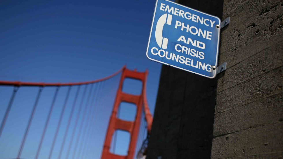 A sign for an emergency phone is seen on the span of the Golden Gate Bridge. An estimated 1,300 people are believed to have jumped to their death from the bridge since it was opened in 1937. (Photo by Justin Sullivan/Getty Images)
