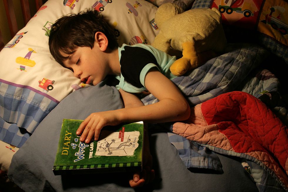 Child asleep holding book