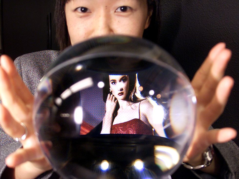 Woman with a crystal ball with an image of someone inside it.