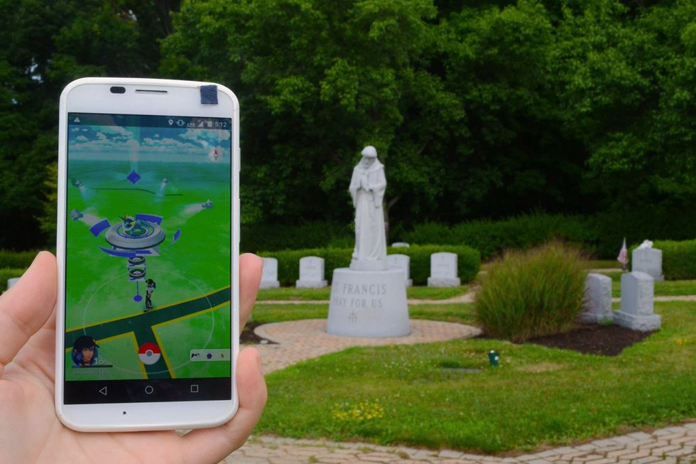 Playing Pokemon Go in a local cemetery in Johnson City, NY. The statue of St. Francis in this memorial park has been deemed a Gym in the augmented reality game.