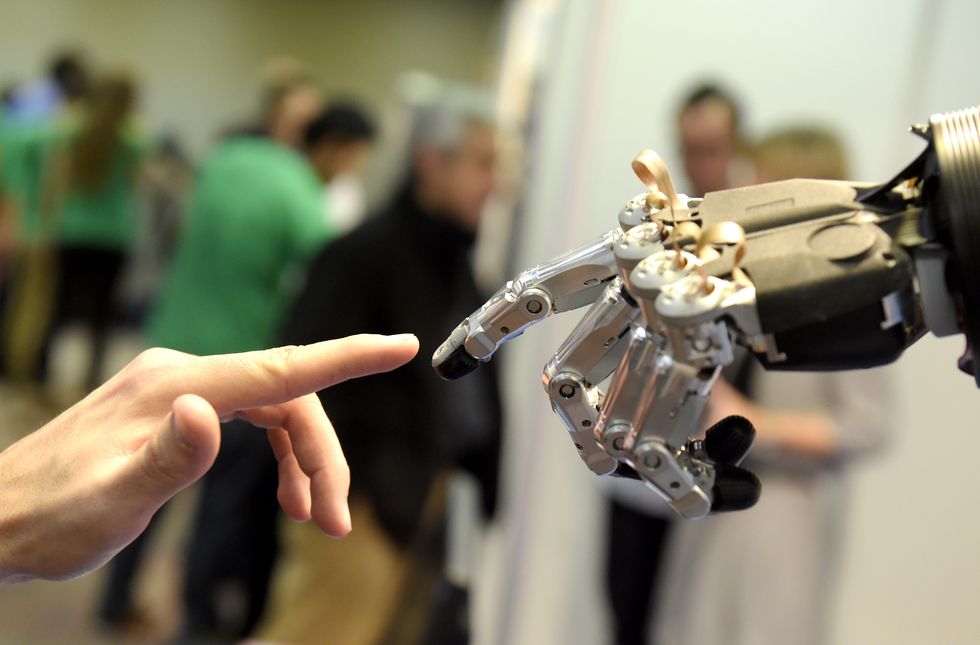 Robot and human hands touching.