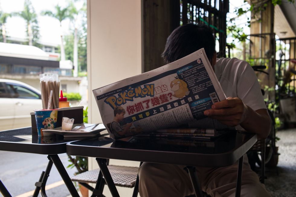 TAINAN, TAIWAN - AUGUST 08: A man reads a Pokemon Go article in the newspaper on August 7, 2016 in Tainan, Taiwan. 'Pokemon Go,' which has been a smash-hit across the globe was launched in Taiwan on 6th August. Since its global launch, the mobile game has