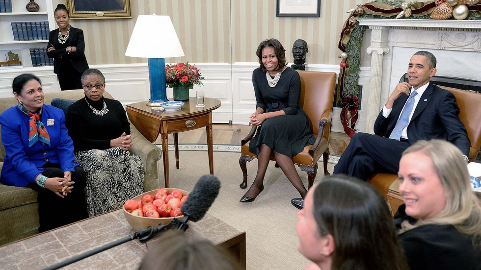 President Barack Obama and first lady Michelle Obama meet with mothers in the Oval Office. (Photo by Olivier Douliery/WHITE HOUSE POOL (ISP POOL IMAGES)/Corbis/VCG via Getty Images)