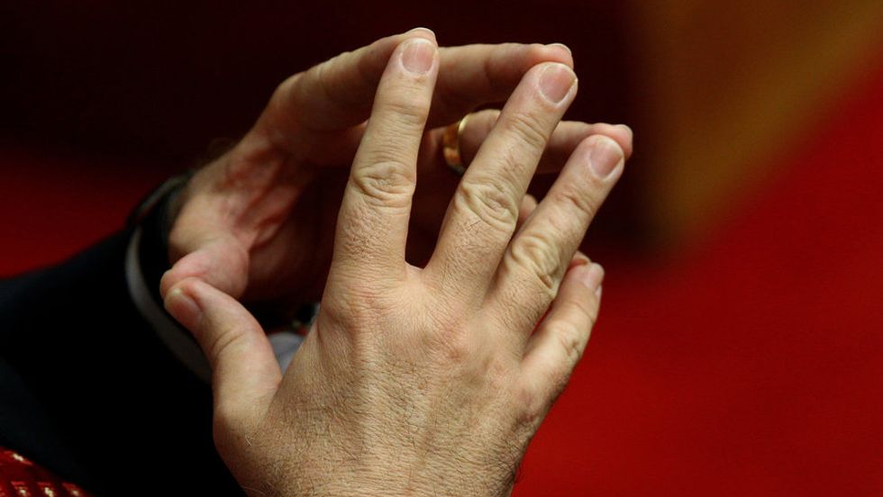 Hands pressed together at the fingertips.