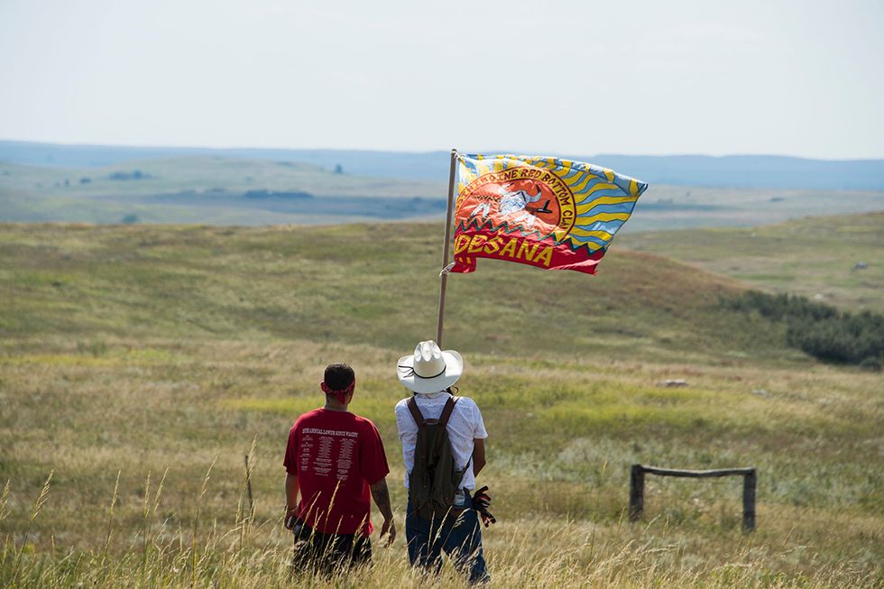 Native American protestors wave a clan flag over land designated for the Dakota Access Pipeline (DAPL), after protestors confronted contractors and private security guards working on the oil pipeline project, forcing them to retreat, September 3, 2016, ne