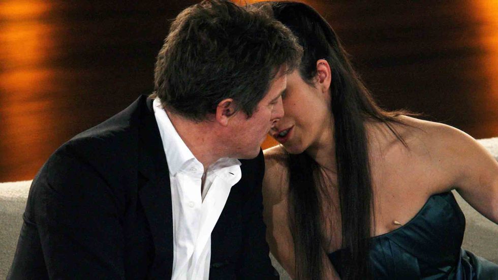 Actors Hugh Grant and Stephanie Stumph flirt during the Wetten dass...? show at the AWD Dome in Bremen, Germany. (Photo by Ronny Hartmann/Getty Images)