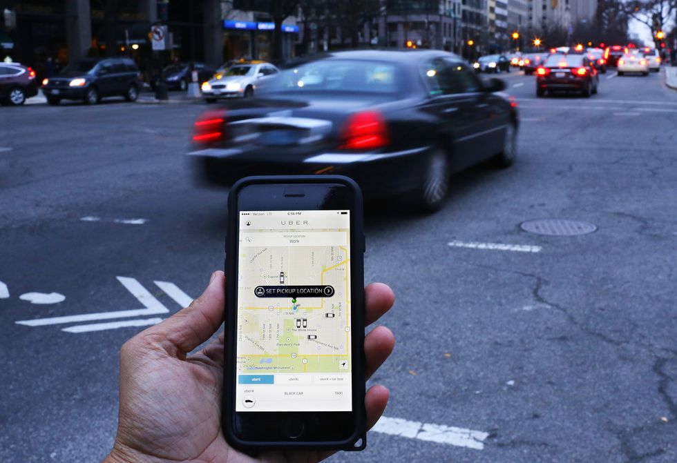 A car speeding past a person using the Uber app, not picking them up. (Photo Andrew Caballero-Reynolds/AFP/Getty Images)