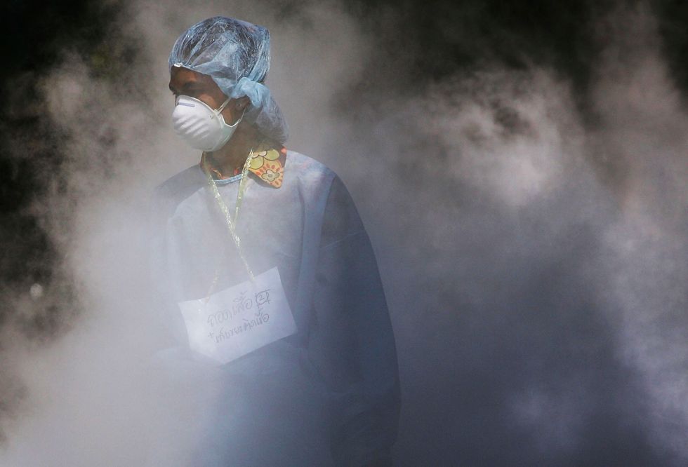 A medical professional walks through dry ice. (Photo by Chris McGrath/Getty Images)
