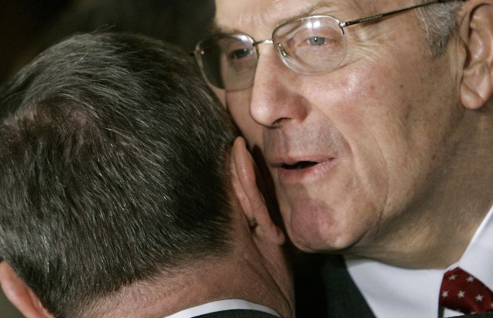 One man whispering into another man's ear. (Photo Paul J. Richards/AFP/Getty Images)