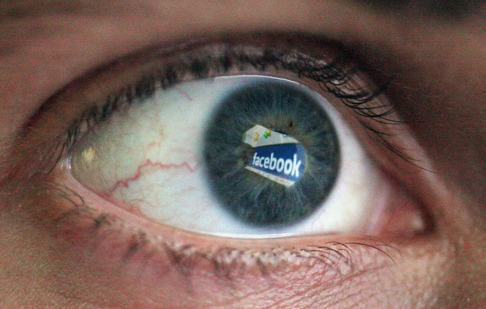 A person's eye with Facebook reflected in it.