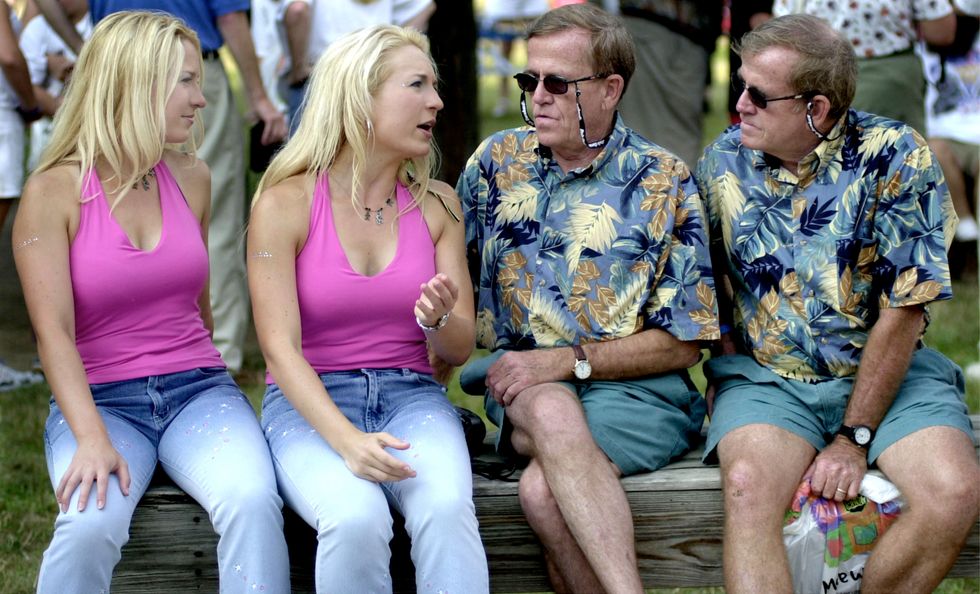 Two sets of identically dressed identical twins talking to each other.