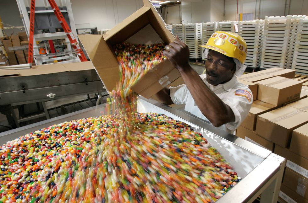 Kennie Bolden dumps jelly beans into a hooper that mixes the candy and gets it ready for packaging at the Jelly Belly candy factory
