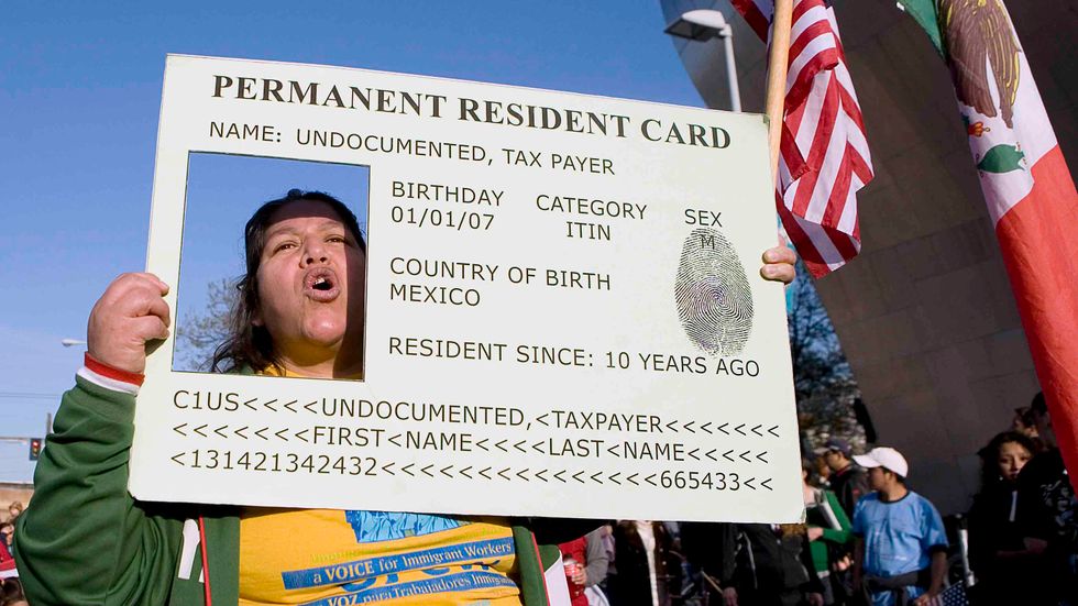 Josephine Corral of Tacoma, Washington, puts her head through a large green card replica during a May Day march May 1, 2008 in Seattle, Washington. (Credit: Stephen Brashear/Getty Images)