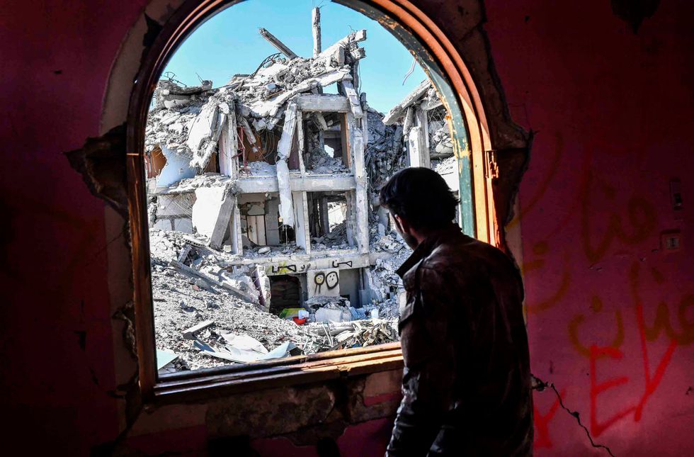 A member of the Syrian Democratic Forces (SDF), backed by US special forces, looks out from a building at the frontline in Raqa on October 16, 2017 in the Islamic State (IS) group jihadist' crumbling stronghold. (BULENT KILIC/AFP/Getty Images)