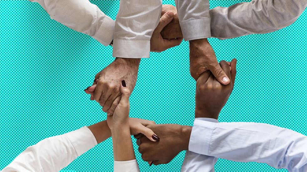 People of different ages, gender, and race holding hands.