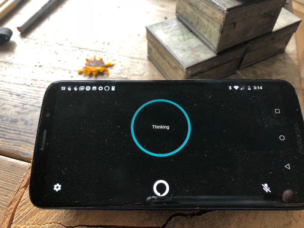 Picture of Moto smartphone screen with Moto smart speaker playing music.