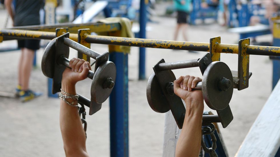 A person lifts dumbbells on August 18, 2017 at an open air gym in Ukraine's capital Kiev. (Photo by Genya Savilov/AFP/Getty Images)