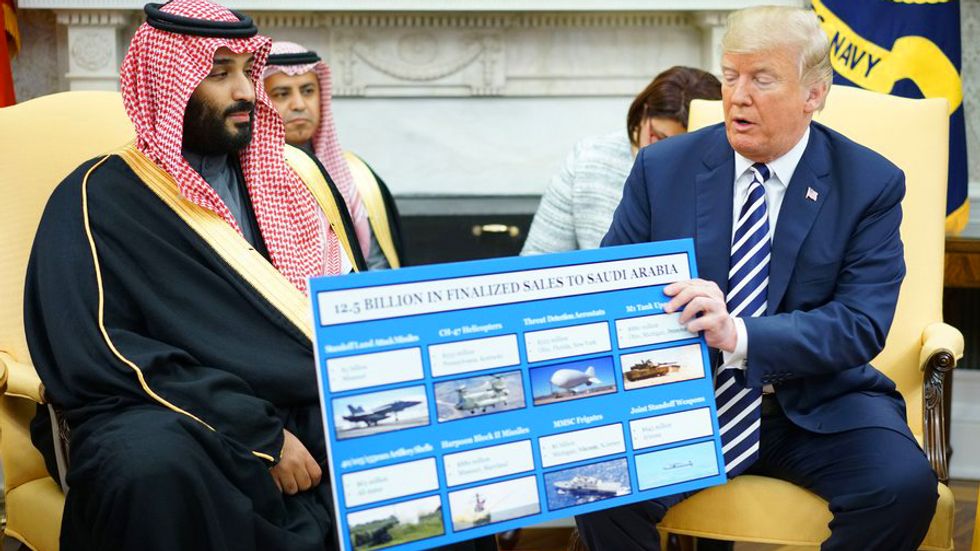 US President Donald Trump (R) holds a defense sales chart with Saudi Arabia's Crown Prince Mohammed bin Salman in the Oval Office of the White House on March 20, 2018 in Washington, DC. (Photo credit: MANDEL NGAN/AFP/Getty Images)