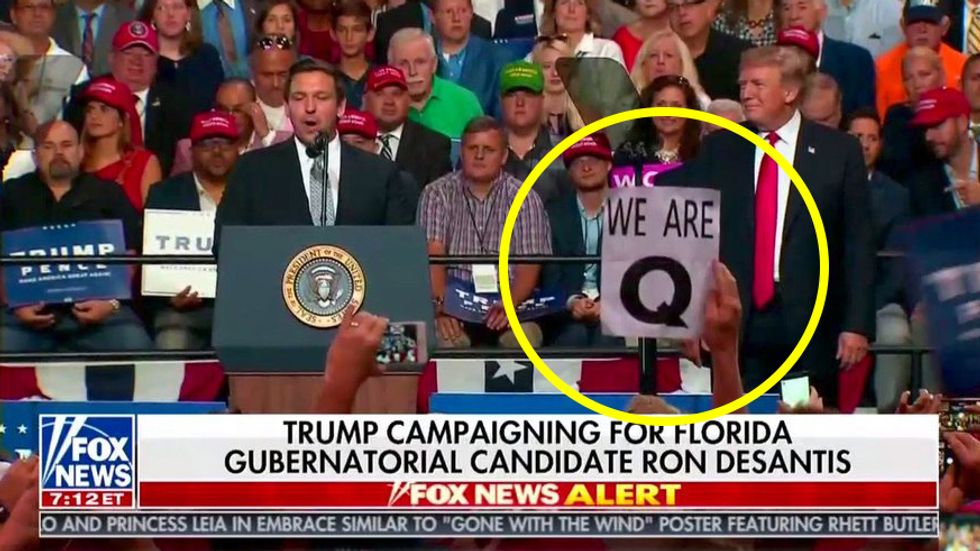 What is QAnon? People hold a "We are Q" sign at Trump rally.