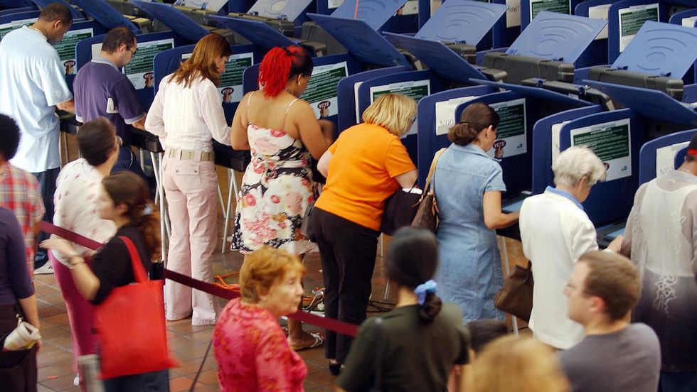 Residents of Dade county, Florida, use electronic voting machines to cast their votes at a local polling station 29 October 2004, in Coral Gables, Florida. (Photo credit ROBERTO SCHMIDT/AFP/Getty Images)