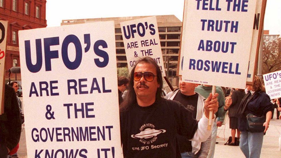 A group of protestors march in front of the General Accounting Office (GAO) 29 March to raise awareness about an examination being conducted by the GAO for documents about a weather balloon crash at Roswell, N.M. in 1947. (JOSHUA ROBERTS/AFP/Getty Images)