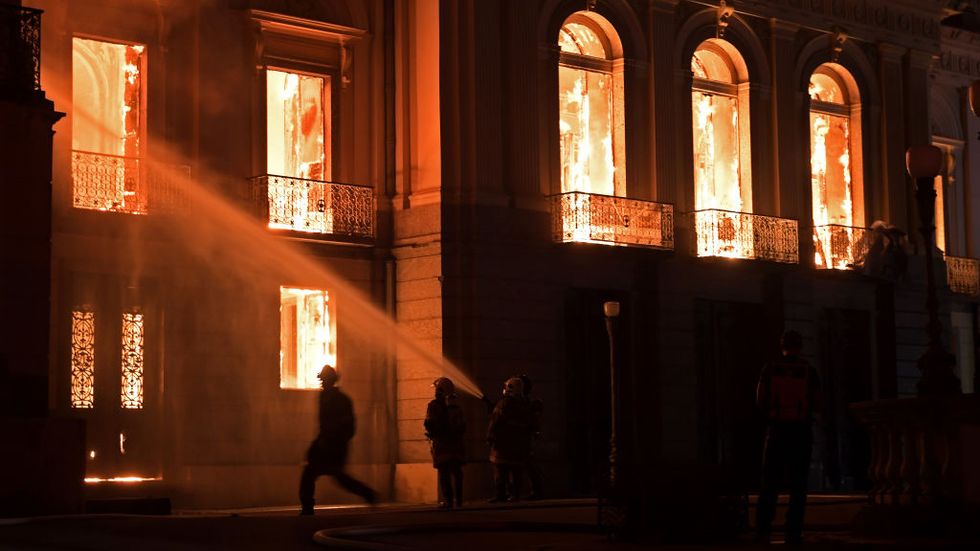 Firefighters work as a massive fire engulfs the National Museum in Rio de Janeiro, one of Brazil's oldest, on September 2, 2018. (Photo by Carl DE SOUZA / AFP / Getty Images)
