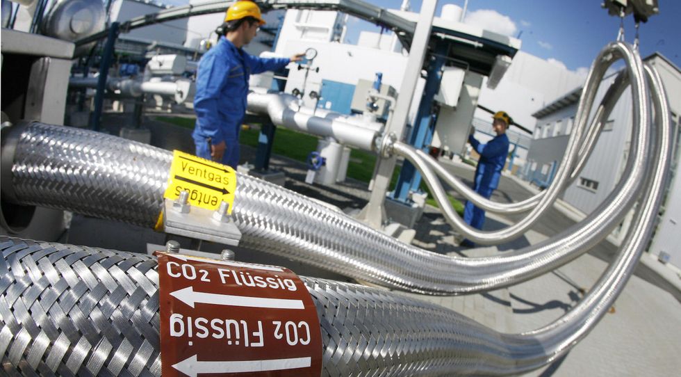 Two employees work on pipes carrying liquid CO2 on September 08, 2008 at the 'Schwarze Pumpe' ('Black Pump') power station run by Europe's biggest power company Vattenfall in Werder near Berlin. (Photo credit MICHAEL URBAN/AFP/Getty Images)