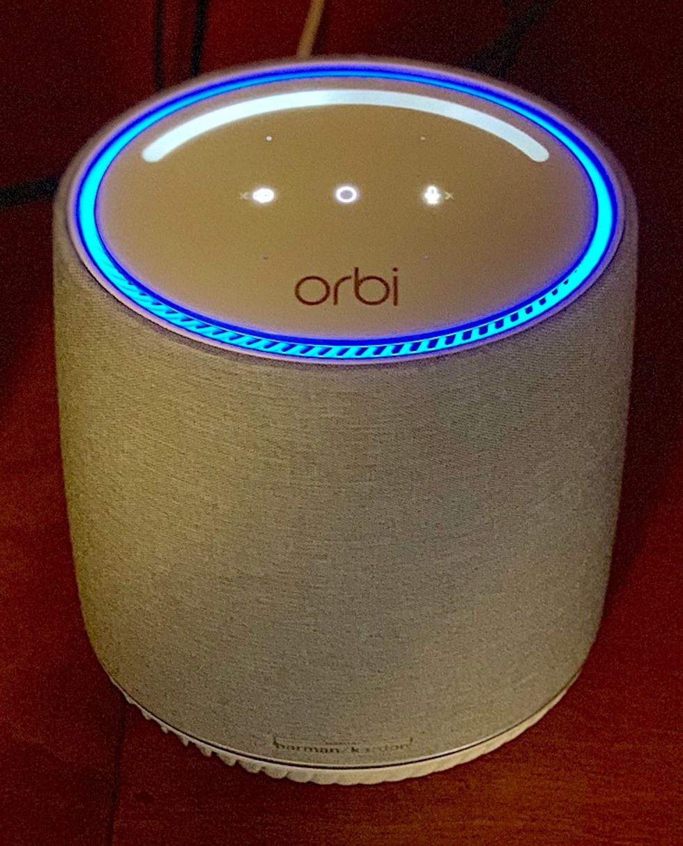 A photo of a rounded speaker, like a cylinder, with the word 'orbi' on the top and three small pinhole lights
