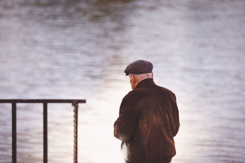 Old man walking near the ocean