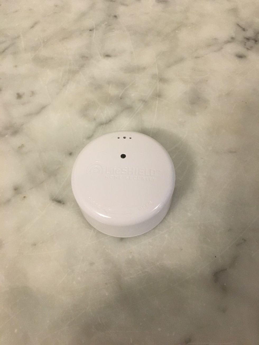 Photo of lifeshield fire safety sensor on a counter.