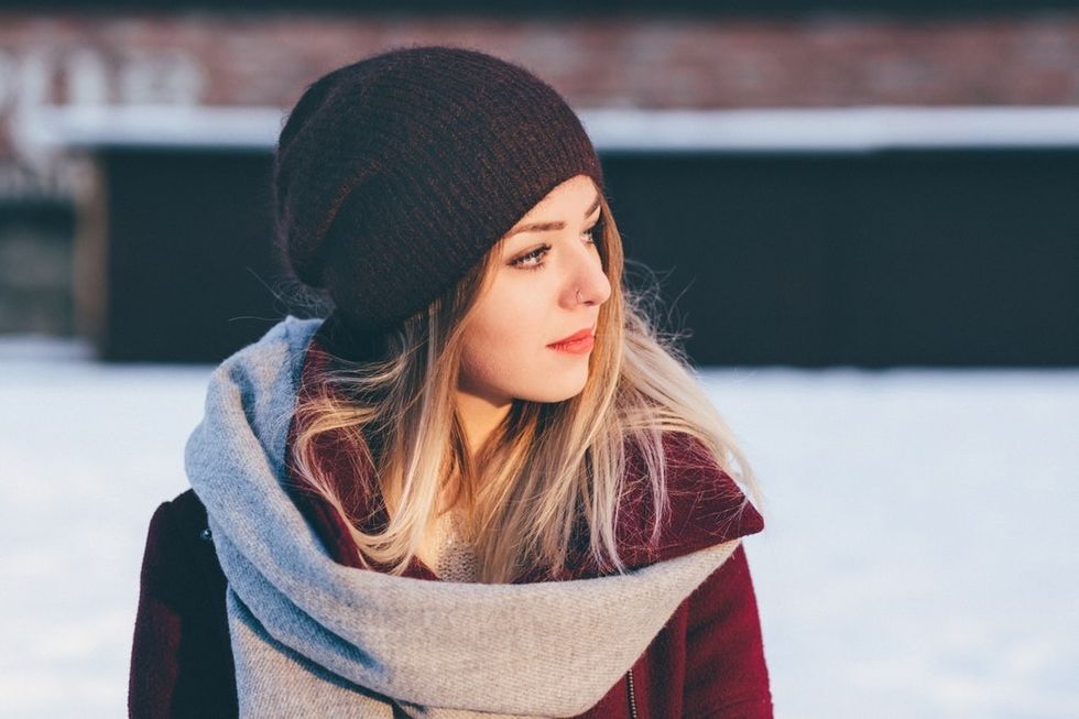 woman in beanie and scarf looking to her side