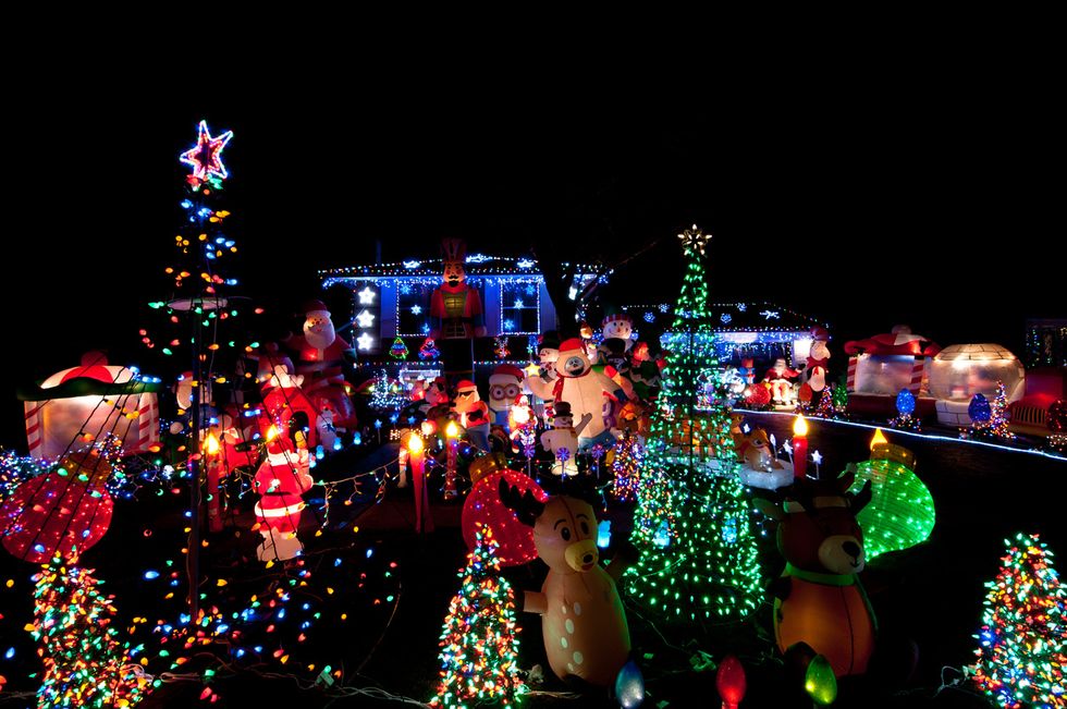 a photo of the outside of a home decorated with lights and other Christmas decorations.