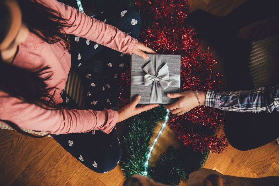 a photo of a person giving another person a gift at Christmas time.