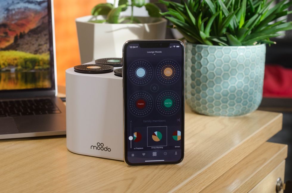 Picture of Moodo Smart Home Fragrance box and smartphone with its app.