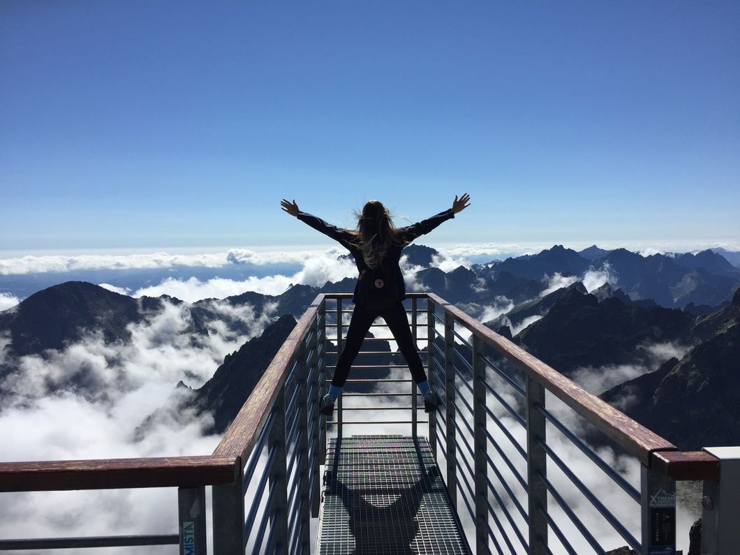 https://www.pexels.com/photo/person-standing-on-hand-rails-with-arms-wide-open-facing-the-mountains-and-clouds-725255/