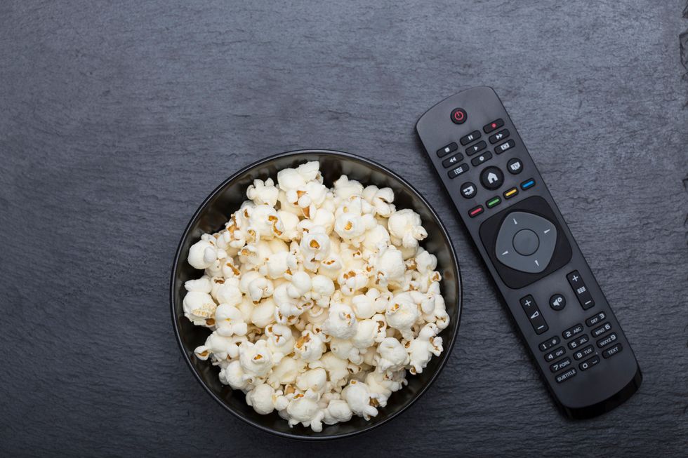 A bowl of popcorn with a remote control