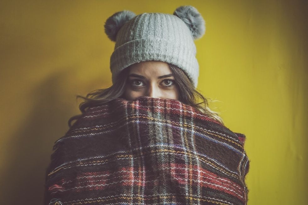 girl bundled in blanket wearing teddy bear ears hat