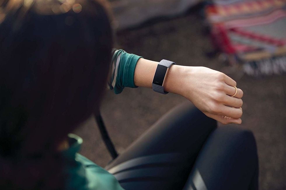 Photo of a woman looking at her Fitbit Charge 3 fitness tracker