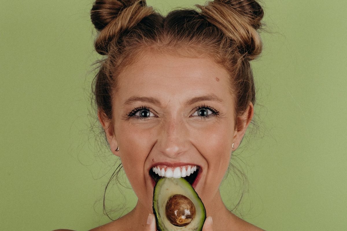 Woman eating an avocado