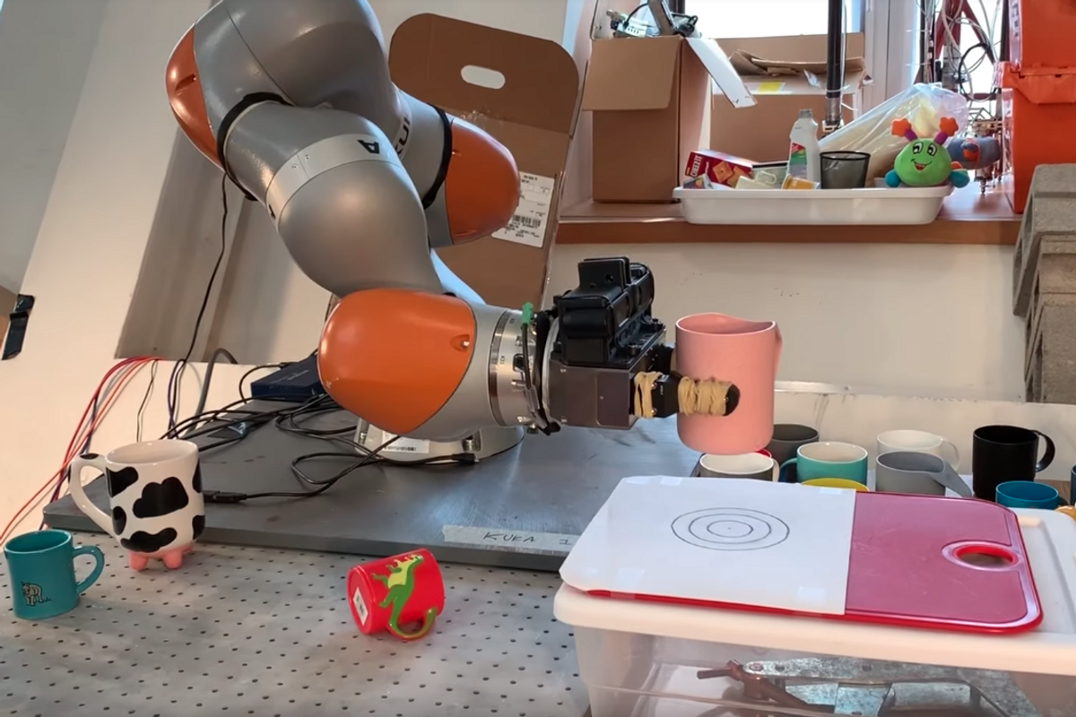 Screenshot of a video showing an MIT robot picking up a mug