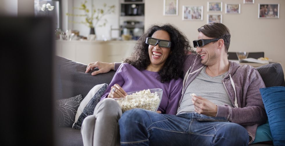 Photo of a couple watching a 3D television, wearing 3D glasses