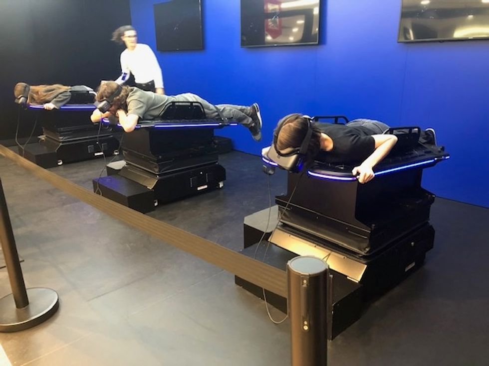 A photo of three people lying on tables, with VR headsets on trying virtual reality content in Madrid, Spain