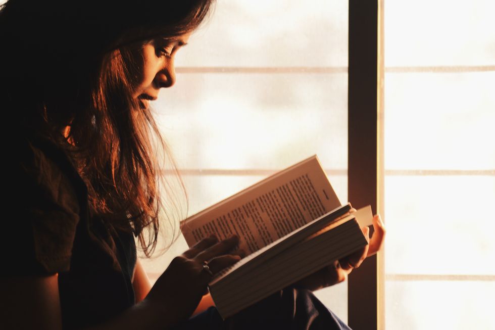 https://www.pexels.com/photo/woman-reading-a-book-beside-the-window-1031588/