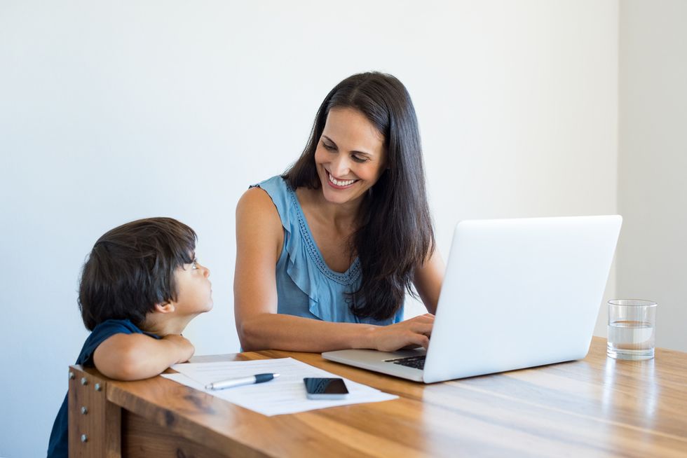 A mother and her child with a contract in front of them near a computer, which can help children and parents follow safety rules