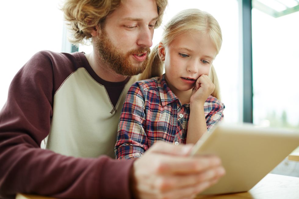 A father talking with a child about how to spend time online safely