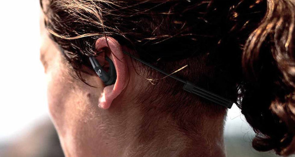 A photo of a woman wearing Jaybirds earbuds in her ears as she exercises