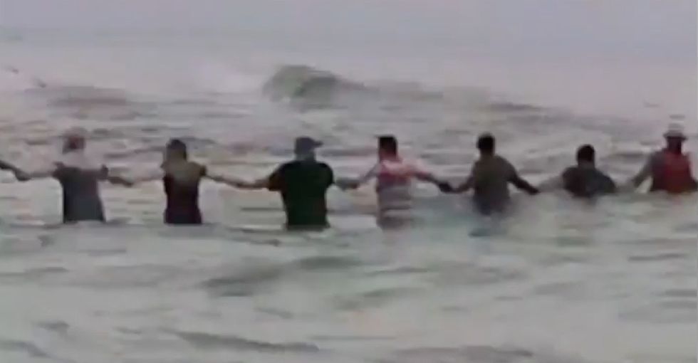 Watch 80 strangers form a human chain to rescue a drowning family.