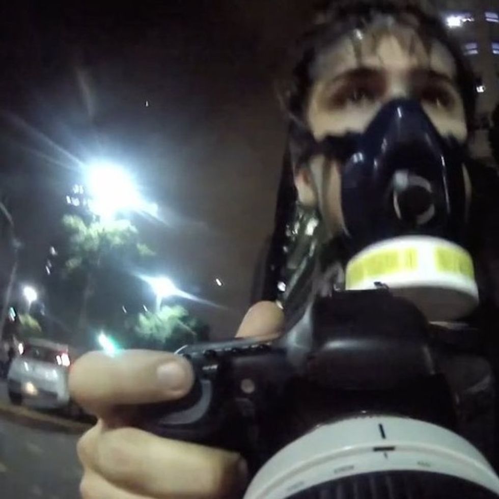 They shoot rubber bullets. He shoots powerful photographs.
