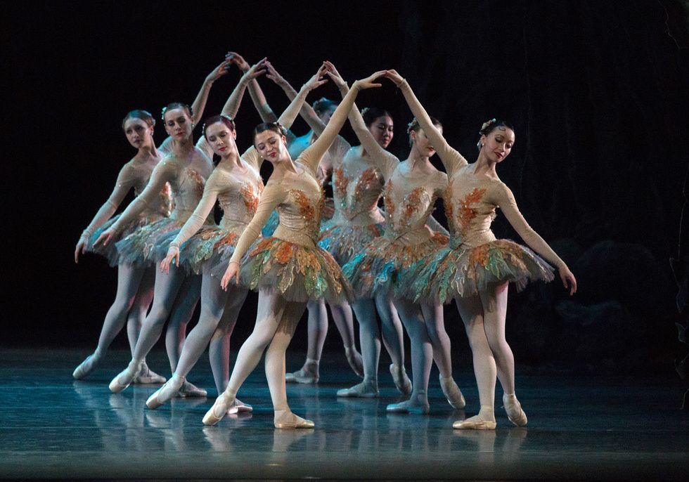 Two lines of corps women stand in b-plus, arms raised toward each other. Hannah Marshall in front