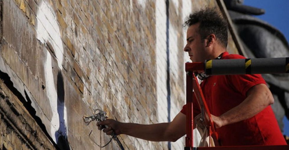 One man is making beautiful reminders of love in unlikely places. One wall at a time.